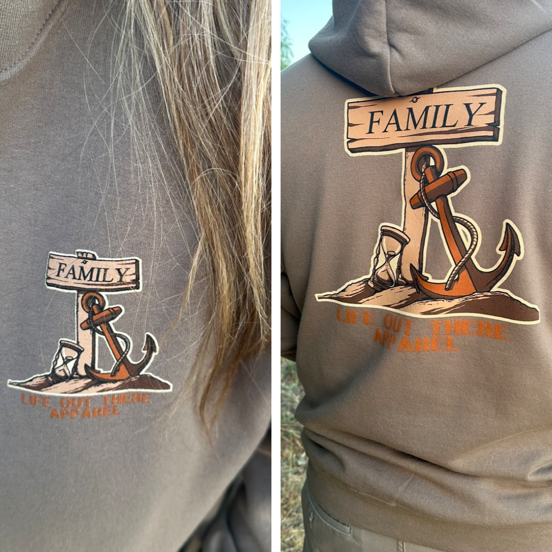 A person wearing the Unisex Time Flies Hoodie in Safari from Life Out There Apparel displays an anchor illustration beside a wooden sign with the word FAMILY, capturing the spirit of TIME FLIES. A close-up on the left prominently highlights this design on the front.