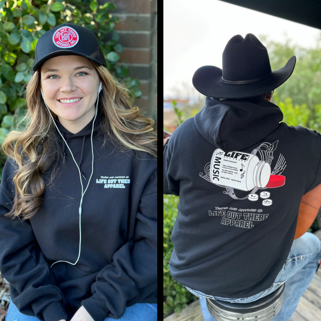 Life Out There Apparel “Music Is Medicine “ The Black Unisex Pullover Hoodie design is a medicine pill bottle tipped over with pills that have fallen out, that have music notes on them. This photo has a girl wearing headphones showing the front of the hoodie & a man in a cowboy hat playing guitar showing the back of the hoodie.