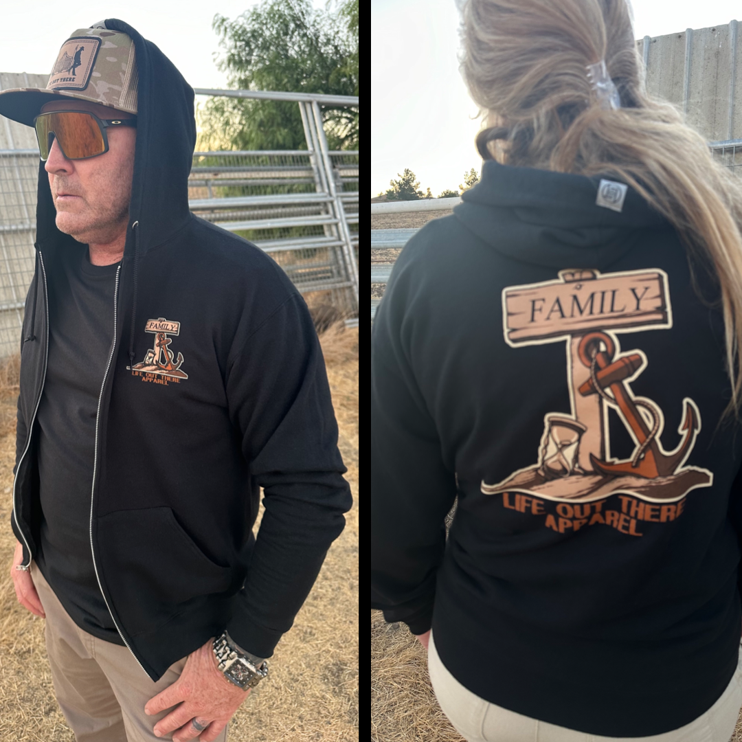 In an outdoor setting, a man sports sunglasses, a cap, and the Unisex Time Flies "Zip-Up" Hoodie in black from Life Out There Apparel. The hoodie features an anchor-themed nautical logo on the front and a back design showcasing an anchor paired with a ship's wheel, accompanied by the text "Family and Life Out There Apparel," encapsulating the essence of Time Flies.