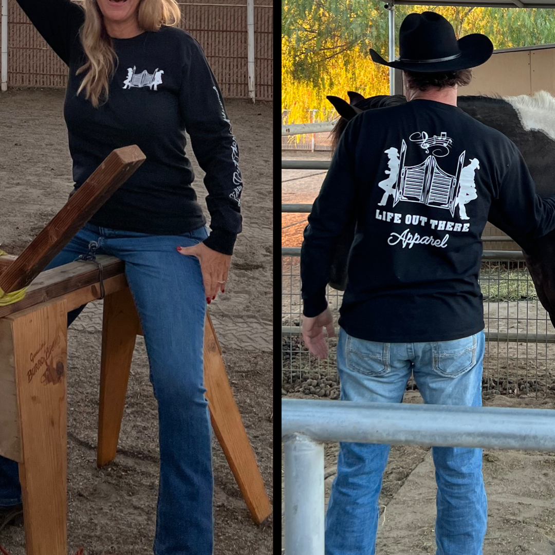 Two individuals wearing the Unisex THE YEEHAW Long Sleeve T-Shirt by Life Out There Apparel stand apart. The first person leans against a wooden structure, while the second, embodying a cowboy style with a hat, stands near a horse. Both shirts feature a Western-themed logo that captures the essence of ranch life.