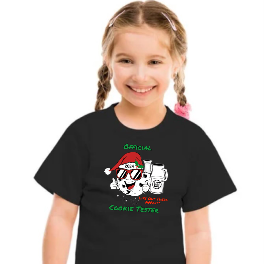 Black short sleeve youth t-shirt with a cartoon cookie wearing a Santa hat and sunglasses labeled "2024," alongside glass milk cartons. Text reads, "Life Out The Apparel / official cookie tester”.