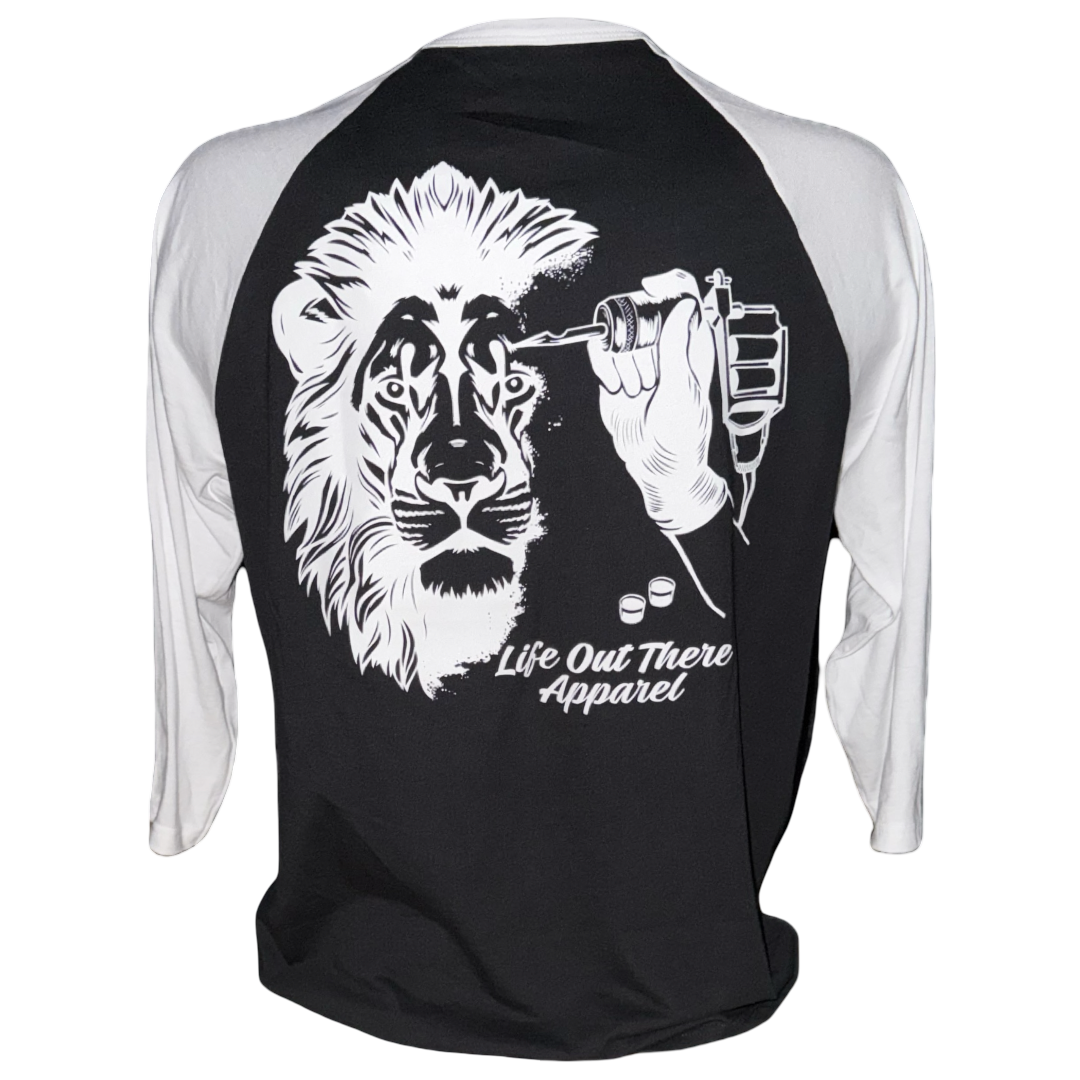 The Life Out There Apparel “Unisex - Not All There 3/4 Sleeve Raglan T Shirt – Black / White” is a tagless 50/50 cotton-poly blend featuring a lion face being tattooed and brand text below the graphic.