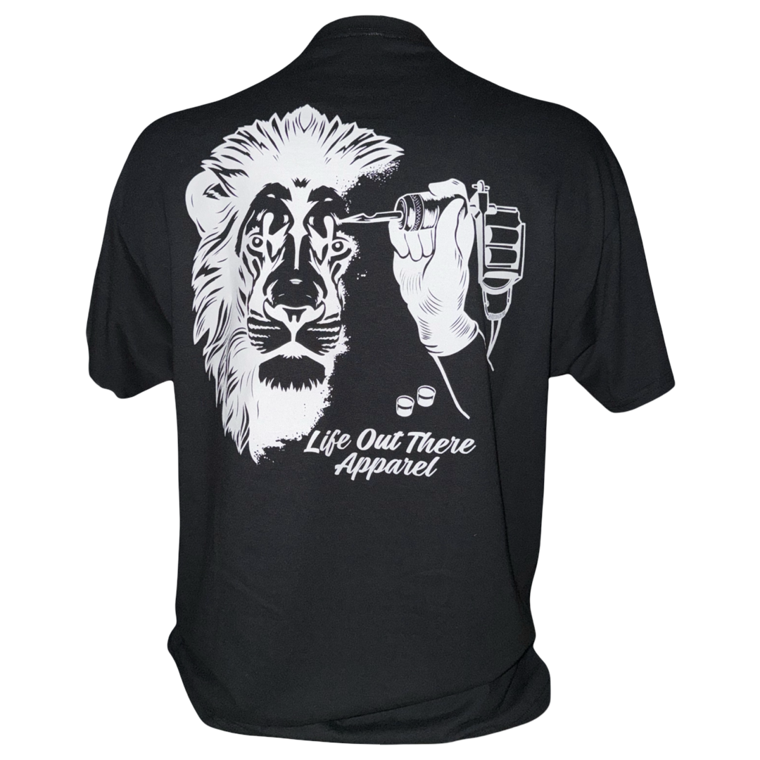 The Unisex - Not All There Tee by Life Out There Apparel features a soft black cotton-poly blend, a white lion face being tattooed graphic, Life Out There Apparel text, and a comfortable tagless design.