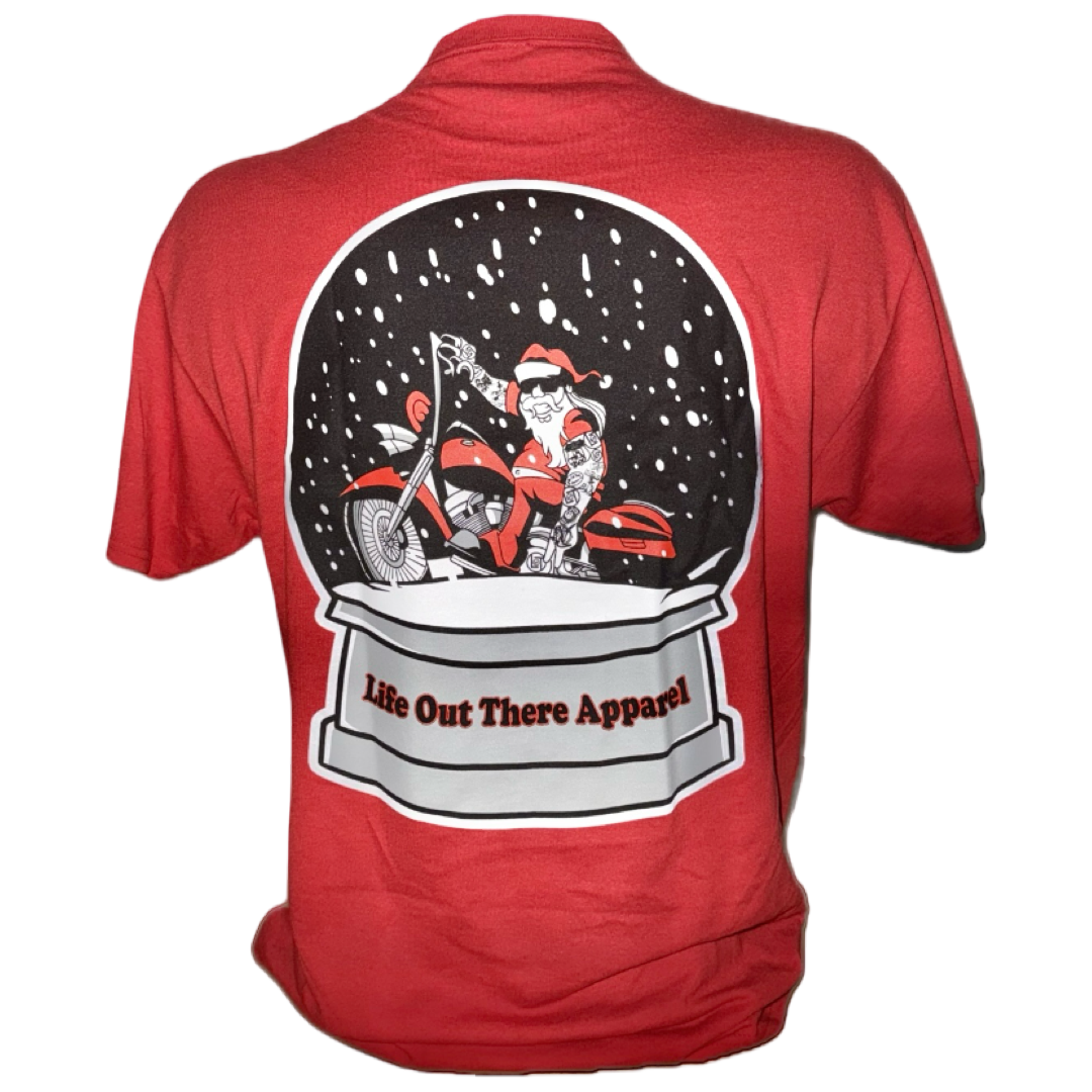 The Unisex - Dashing Through The Snow Tee in red by Life Out There Apparel features a motorcycle rider in a snow globe with falling snow and a festive banner. This limited edition tee is part of our Christmas launch.