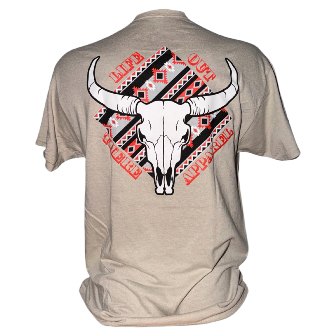 The Longhorn Outlaw Tee - Sandstone by Life Out There Apparel features a striking bull skull graphic set against a vivid red and black tribal pattern. Encircled by the text "LIFE OUT THERE APPAREL," this unisex tee is a bold statement piece from the brand’s LONGHORN OUTLAW collection.