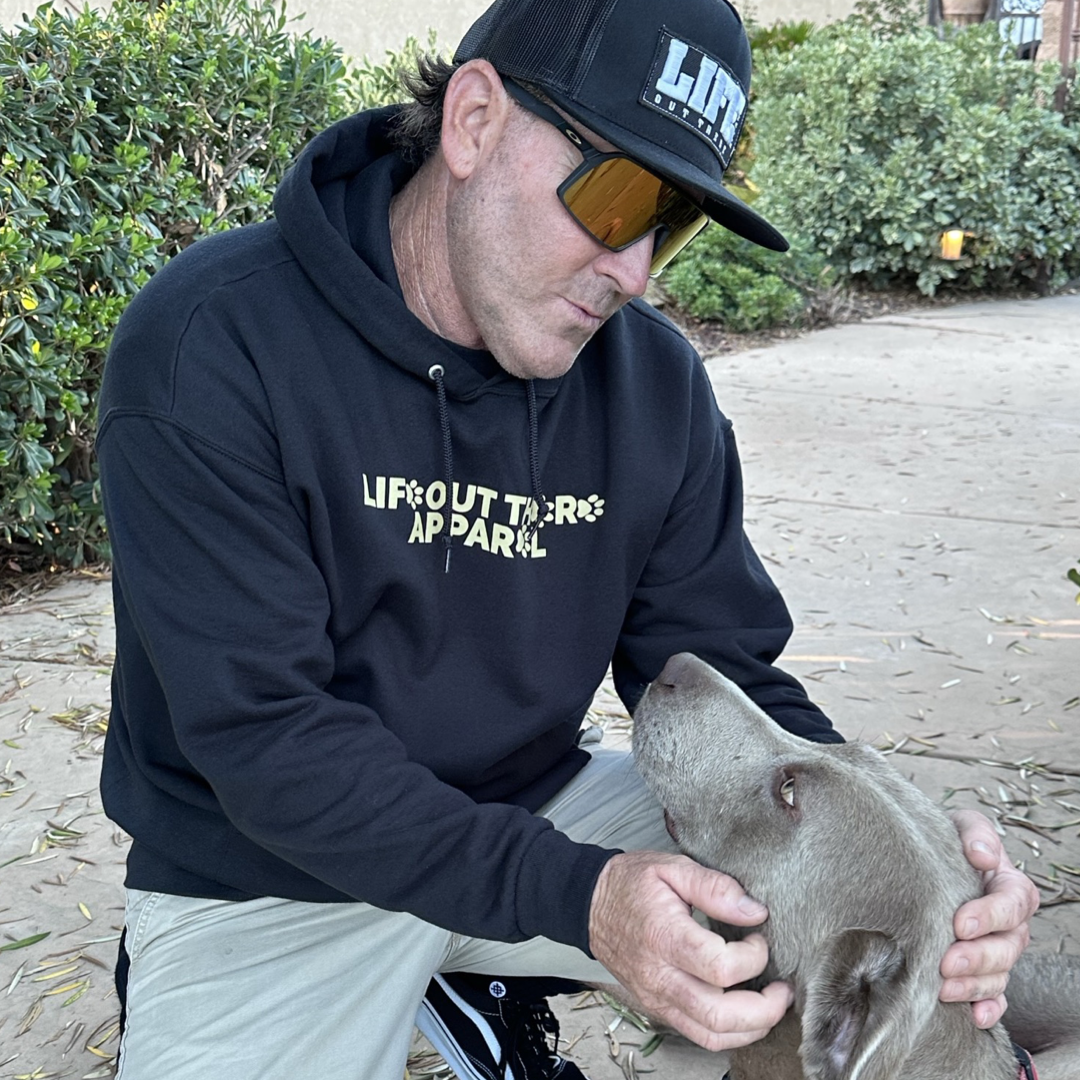 Life Out There Apparel “Best Friend” Unisex hoodie in black. This is a man wearing the hoodie, he is with his best friend, a silver Labrador. This is a tribute to our dogs, our best friend is a Labrador retriever dog on a hike with his humans.