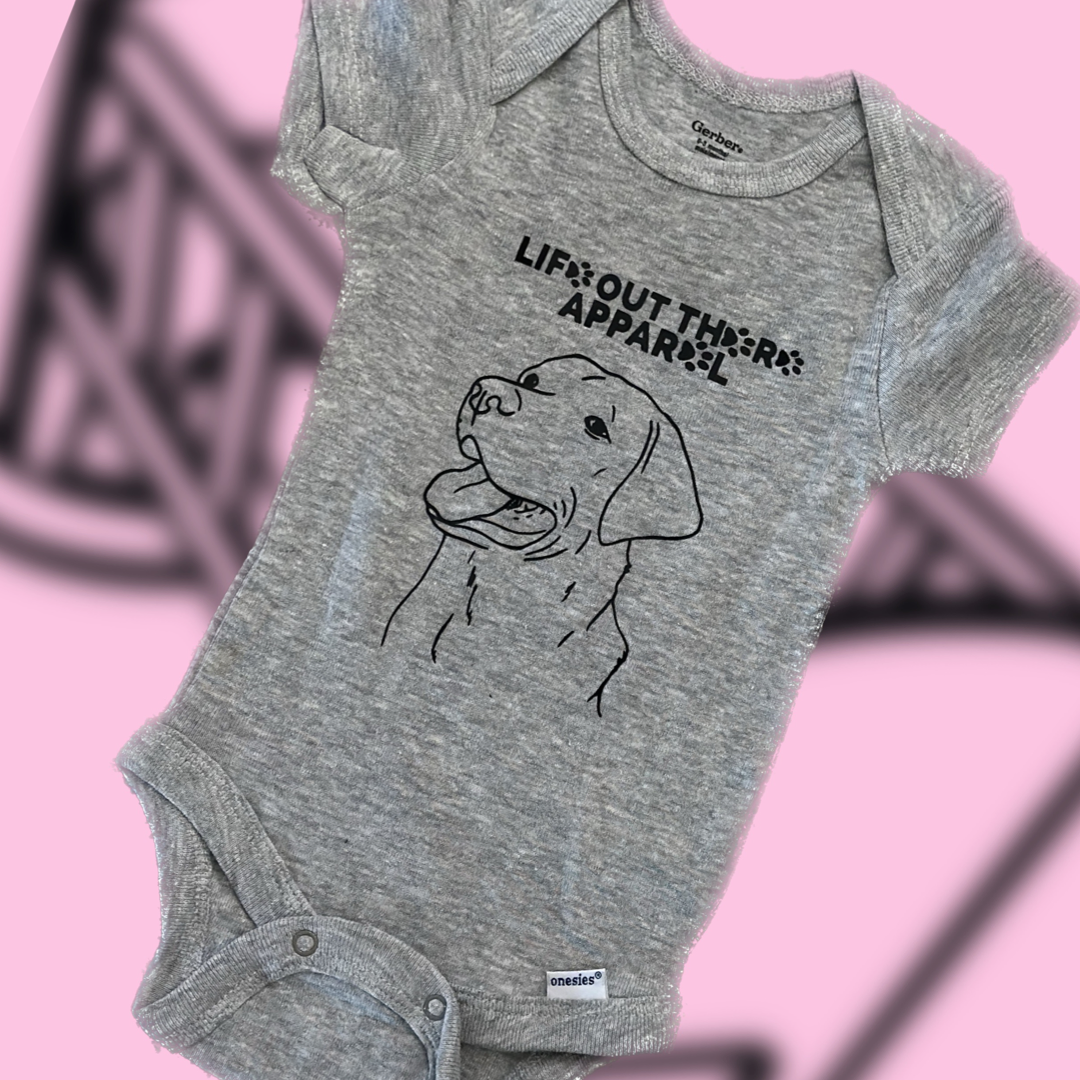 Unisex Best Friend Baby Onesies in gray, featuring a line drawing of a dog symbolizing unconditional love and the text "Life Out There Apparel" on the front, set against a pink background.
