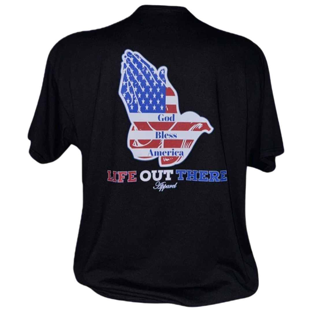Celebrate the 4th of July 2024 in style and showcase your pride for the United States with the Unisex God Bless America T-Shirt from Life Out There Apparel. This black tee features an image of praying hands adorned with an American flag pattern on the back, along with the text "God Bless America." The red and blue "Life Out There Apparel" branding below adds a patriotic touch.