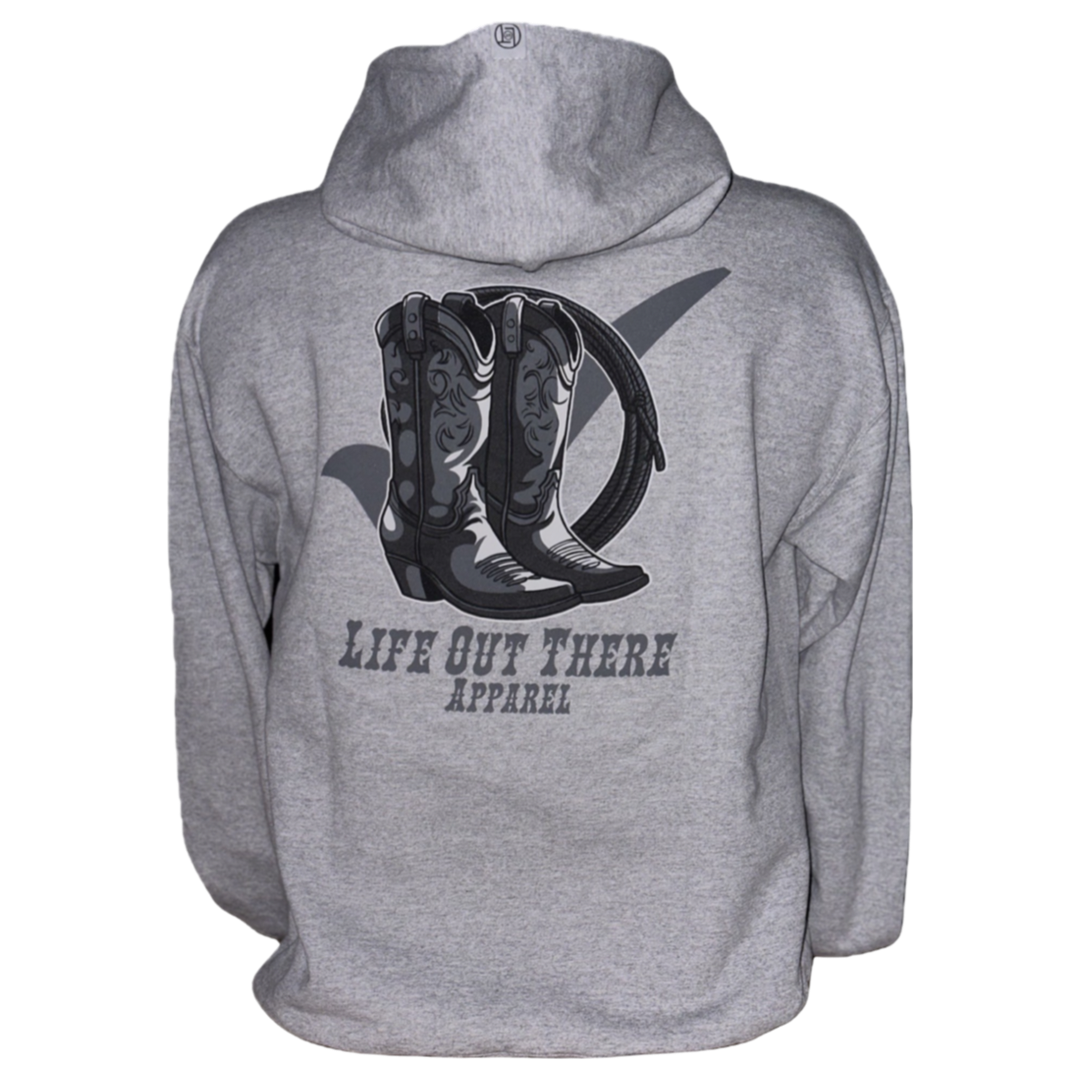 The Unisex Boot Check Hoodie in Oxford Grey features an illustration of cowboy boots and a hat, with "Life Out There Apparel" on the back. This design embodies adventure while promoting awareness and compassion for those around us.