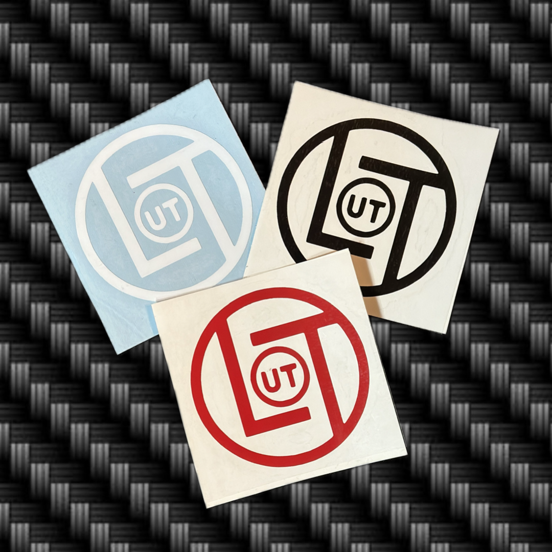 Three 3-inch die-cut square stickers from Life Out There Apparel, each showcasing a circular logo with the letters UT in the center. The logos come in blue, black, and red against a textured carbon fiber background.