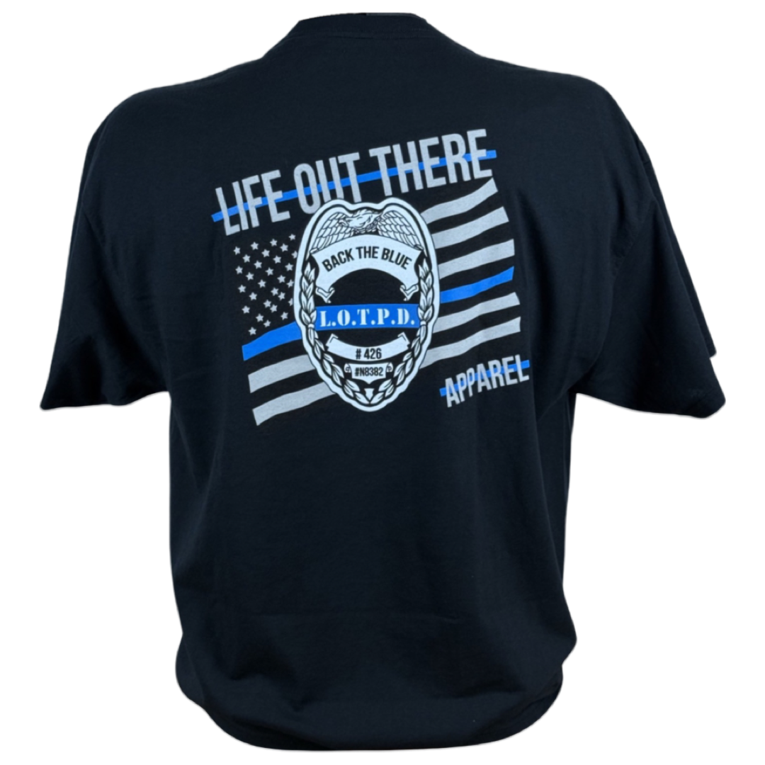 This black, tagless t-shirt from Life Out There Apparel is a comfortable cotton blend featuring a police badge graphic with "Back the Blue" and "L.O.T.P.D." in the center. The design includes an American flag with a blue line and the text "Life Out There," showcasing their Unisex - Back The Blue Tee.