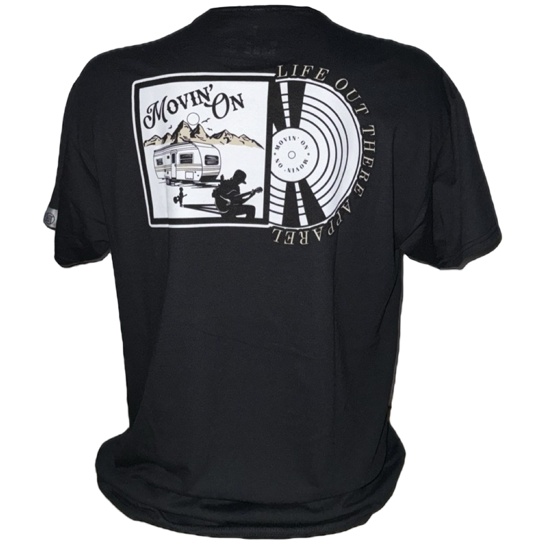 The Unisex - Movin On Tee - Black by Life Out There Apparel features a camper, mountains, and a guitarist with MOVIN ON and “Life Out There A Travel” text, plus circular patterns and a vinyl record-inspired design.