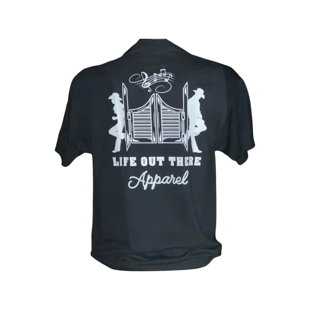 Introducing the Unisex THE YEEHAW T Shirt from Life Out There Apparel. This black tee showcases a white graphic design, ideal for cowboy-themed outfits. It depicts two cowboy figures sitting back-to-back against a saloon door, with musical notes overhead, perfectly capturing the essence of country music. The decorative text proudly displays "Life Out There Apparel.