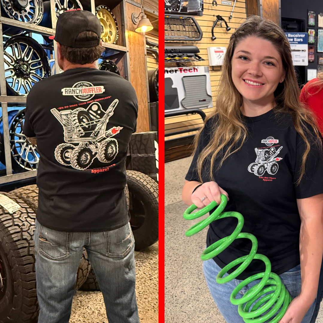 Side-by-side images: Left, a man views off-road wheels and Jeep gear; right, a smiling woman holds a green coil spring. Both wear the Life Out There Apparel Unisex "We Do More Than Just Mufflers" Tee in black.