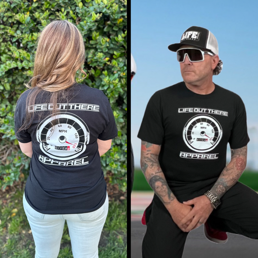 Life Out There Apparel “On My Way” Black Unisex tee shirt is the 1 year anniversary design that has a big speedometer on it - pegged at 120 mph & the odometer is rolling over 1 Year. This photo shows a young lady showing the back of the shirt & a man showing the same design on the front of the shirt.  