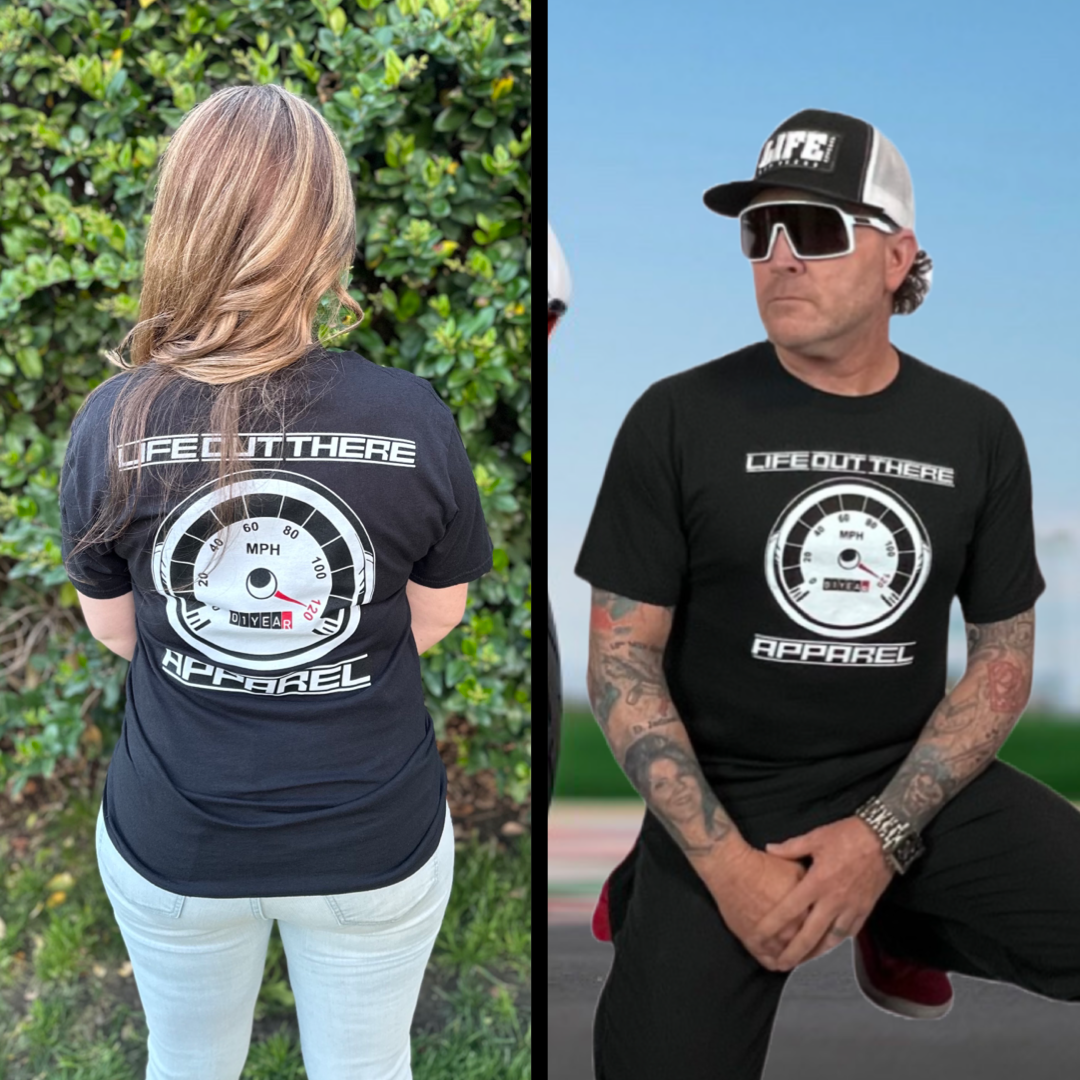 Life Out There Apparel “On My Way” Black Unisex tee shirt is the 1 year anniversary design that has a big speedometer on it - pegged at 120 mph & the odometer is rolling over 1 Year. This photo shows a young lady showing the back of the shirt & a man showing the same design on the front of the shirt.  