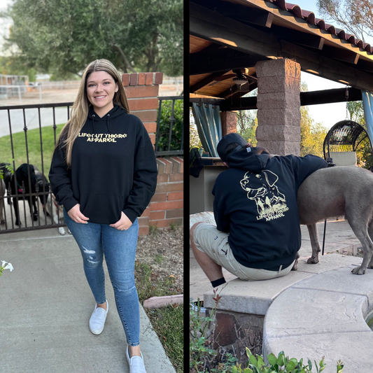 Life Out There Apparel “Best Friend” Unisex hoodie in black. This is a man & a women wearing the hoodie, he is with his best friend, a silver Labrador. This is a tribute to our dogs, our best friend is a Labrador retriever dog on a hike with his humans. 