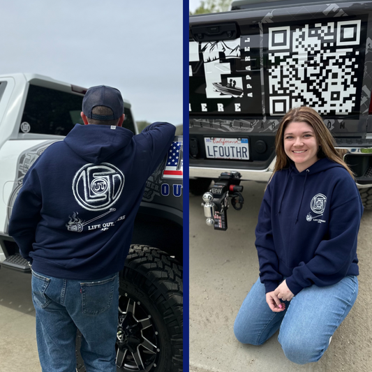 Life Out There Apparel “Branded” Unisex hoodie in navy is a round logo of the companies initials, made with a hot branding iron. This is a photo of a man & young lady wearing the hoodie.  