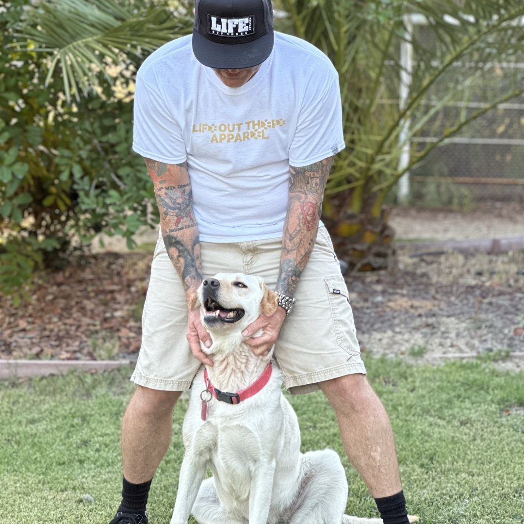 Life Out There Apparel “Best Friend” Unisex tee shirt in white. This is a guy with his best friend, a yellow Labrador. This is the front of the shirt with paw prints. Our best friend is a Labrador retriever dog on a hike with his humans. 