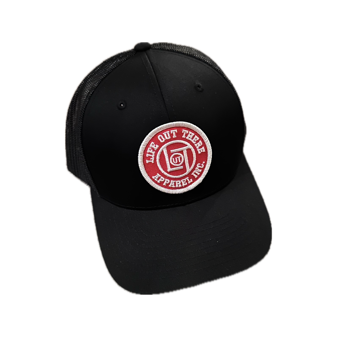 The LOT Curved Bill Snapback Trucker Hat in black by Life Out There Apparel features a curved bill, a mesh back, and a circular patch on the front. The patch is red with white text that reads "Life Out There Apparel Inc." and includes a small emblem in the center.