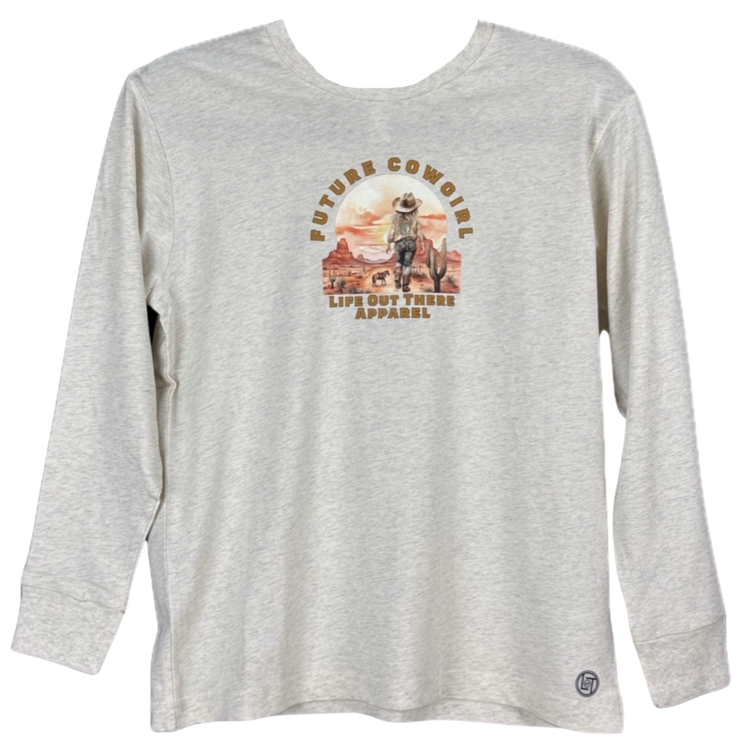 A natural beige long-sleeve shirt from Life Out There Apparel features a graphic of a child as a cowgirl above desert landscape imagery, with the text Future Cowgirl, capturing the rustic charm of country music.