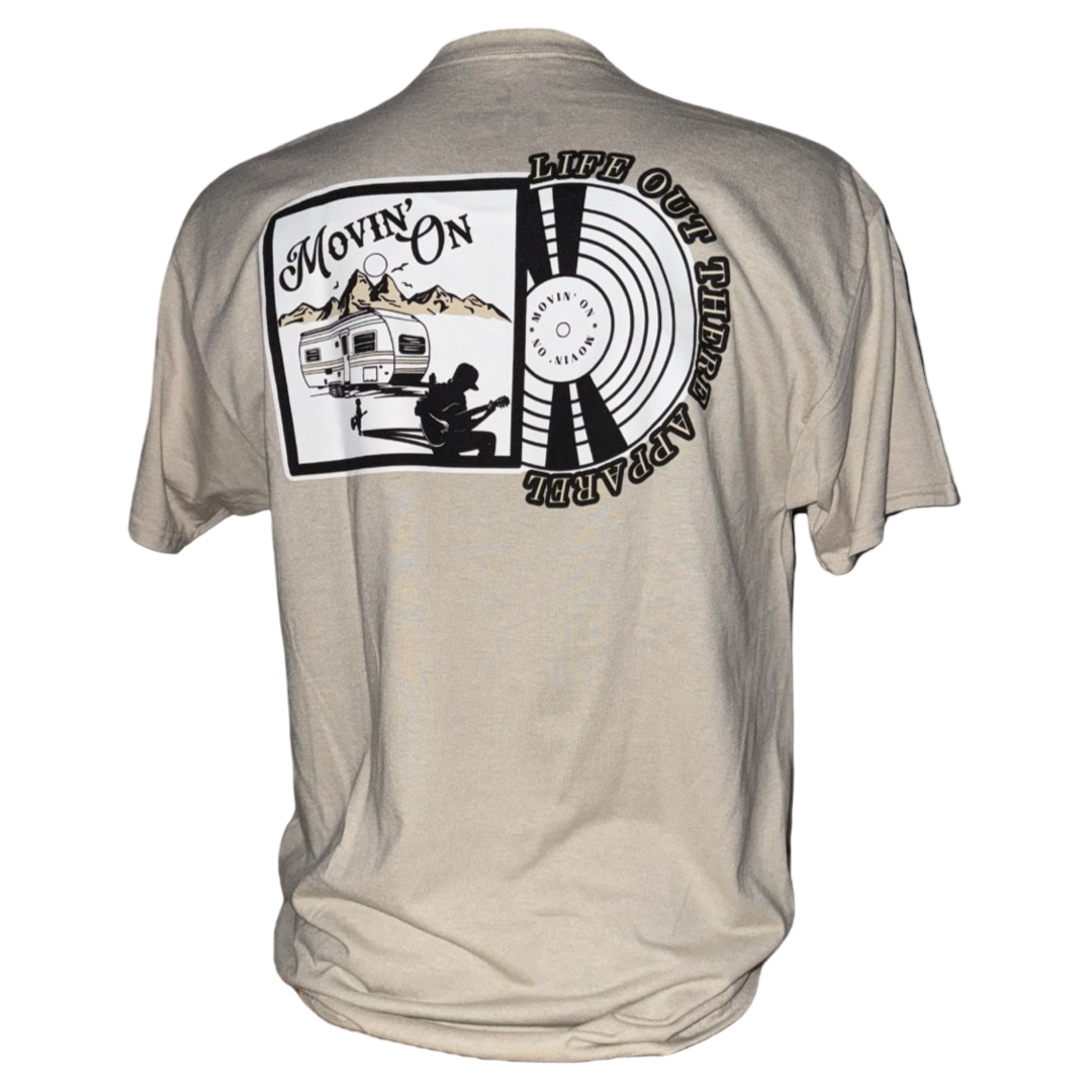 The Unisex Movin On Tee in Sandstone by Life Out There Apparel features a back graphic of an RV in the desert with mountains, “MOVIN’ ON,” and a circular Life Out There Apparel design by Jeremiah Watson.