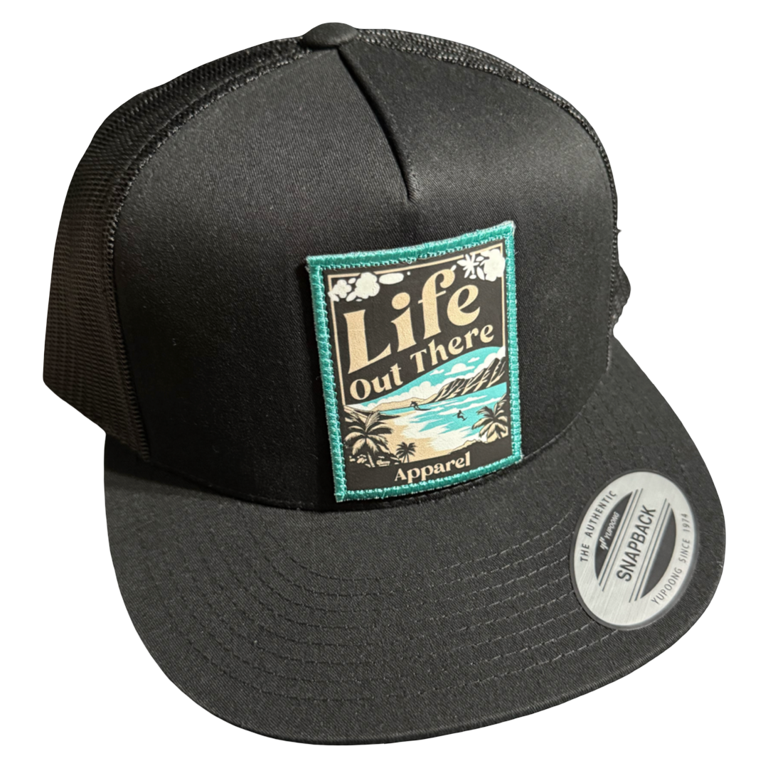 The ALOHA - Flat Bill SnapBack Trucker Hat in Black by Life Out There Apparel features a mesh back and a front patch with a tropical beach scene, adding Hawaiian vibes and a touch of ALOHA to your look.