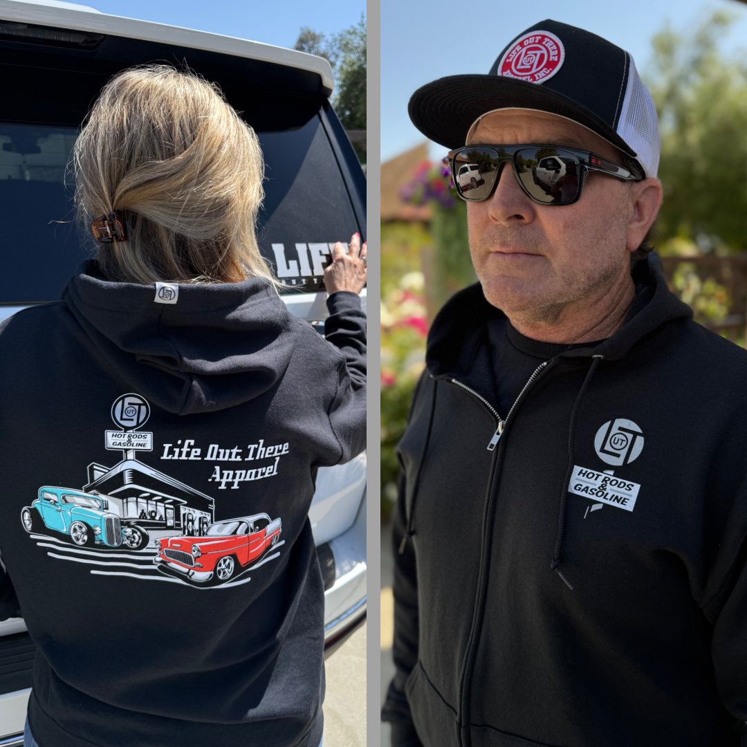 Two people in black Cruzin Zip-Up Hoodies by Life Out There Apparel, featuring vintage hot rod cars, a Chevy Bel Air, and a garage graphic on the back—an ideal Father’s Day gift for classic car fans.