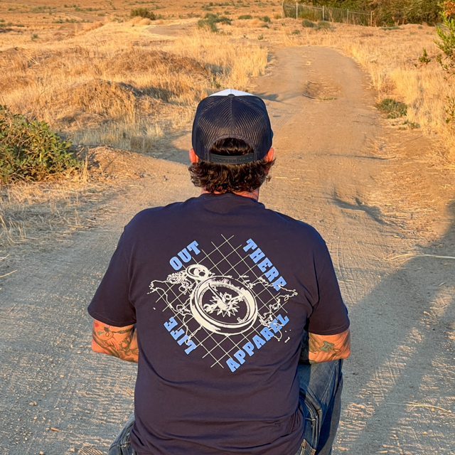Life Out There Apparel “A New Path” Unisex navy blue tee shirt has a man wearing this shirt. This tee shirt has a nautical feel with a compass on top of an atlas. This design was created in support of suicide awareness. 