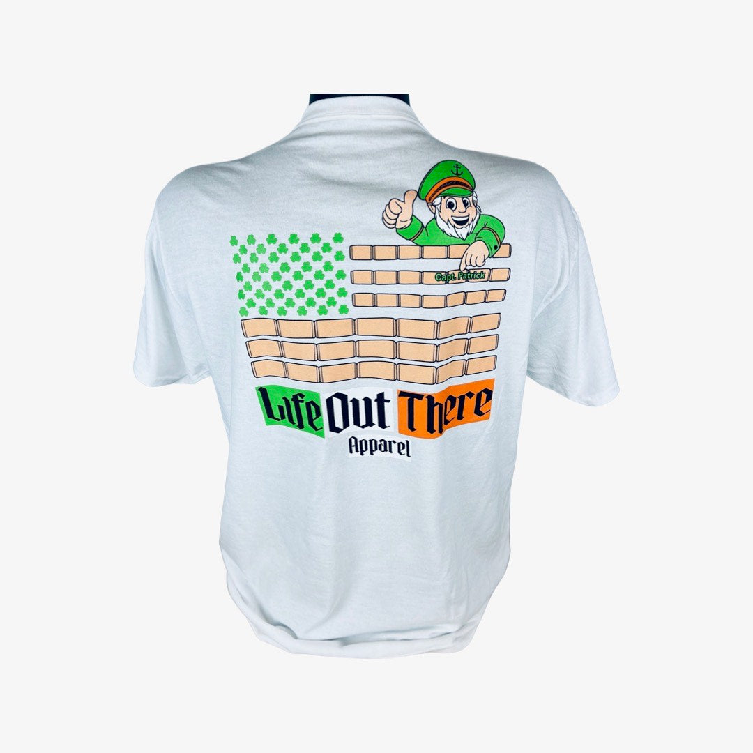 Life Out There Apparel “Capt. Patrick” Unisex tee shirt in white is a collaboration of an American flag with an Irish twist and a leprechaun boat Captain looking on. 